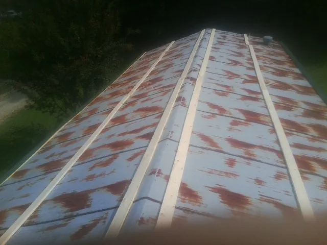 Rusted metal roof panels with new wood purlins before replacement — Storm Damage Roof Repair in Mount Union by Roofing Brothers