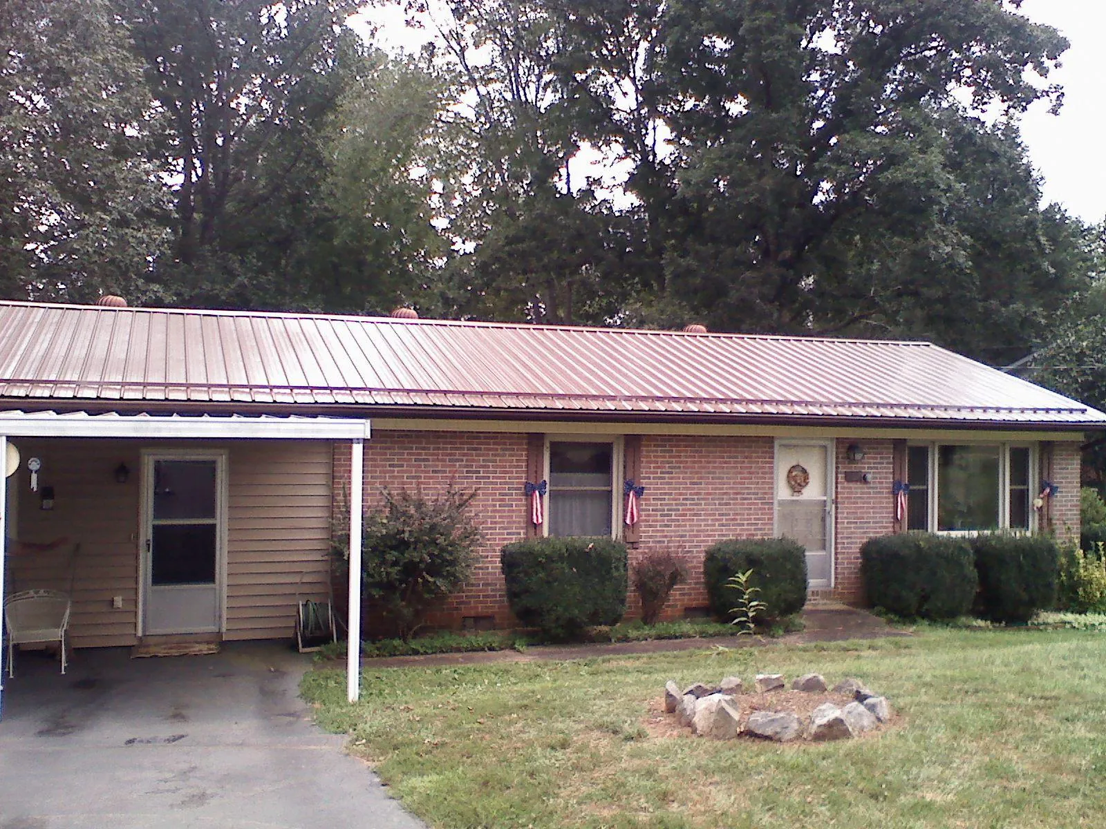 Bronze metal roof and carport on a brick ranch home — Roof Repair work by our crew in Mount Union