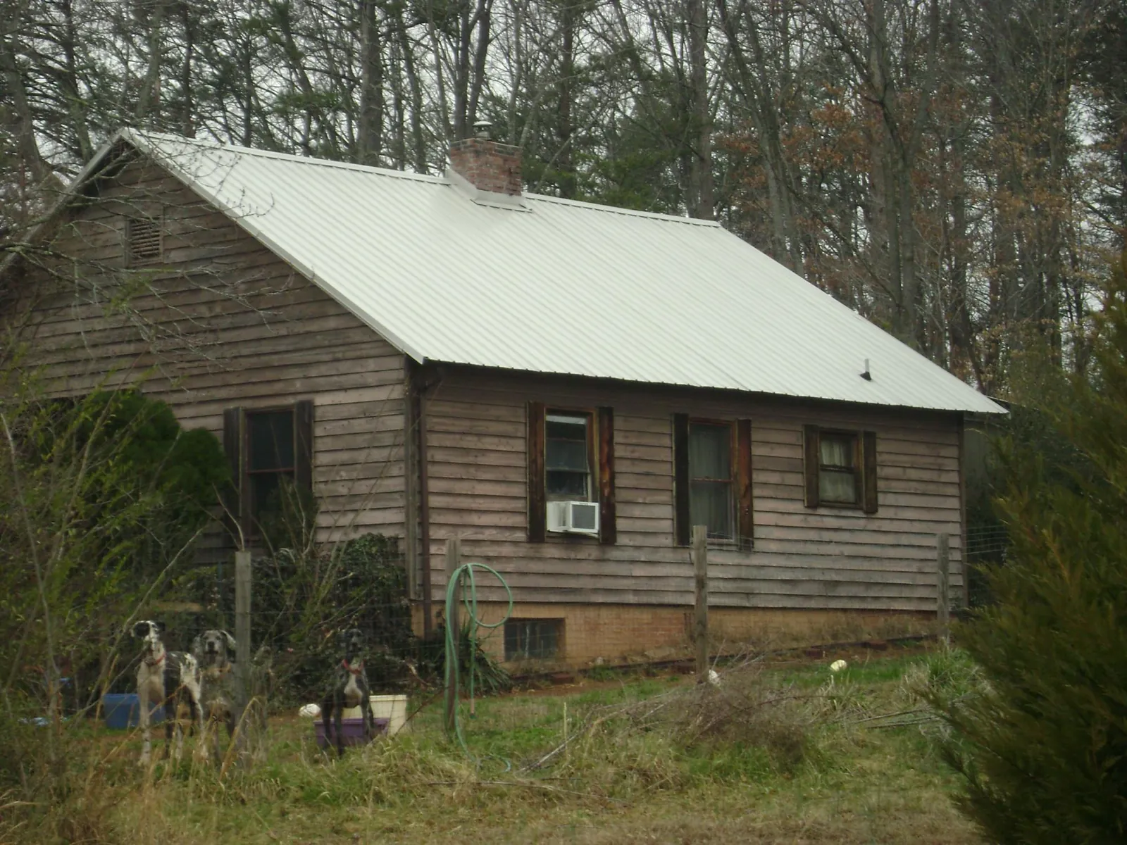 White metal roof on an old wood sided farmhouse, from a Metal Roof Installation job in Mount Union