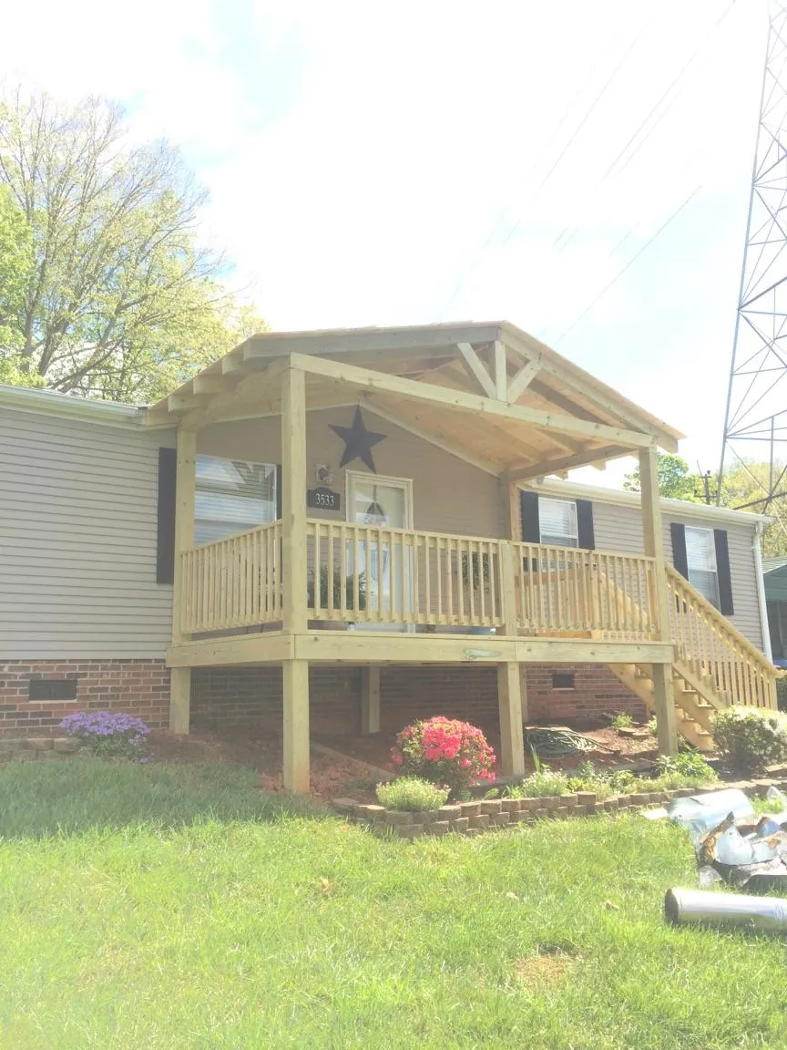 New gabled porch roof and deck railing added to a ranch home in Mount Union